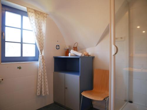 a small bathroom with a shower and a chair at Fini in Am Schwarzen Busch