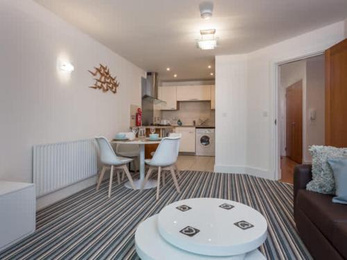 a living room with a couch and a table at Reflections - Balcony Views of Poole Harbour in Poole