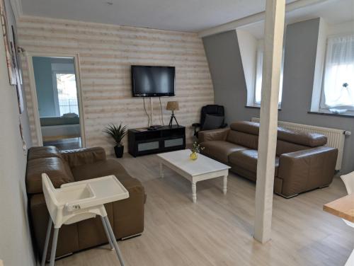 a living room with a couch and a tv at Murgtalhouse Ferienwohnungen in Murg