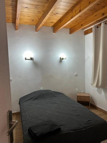 une chambre avec un lit et deux lampes murales dans l'établissement Au cabanon, à Port-Saint-Louis-du-Rhône