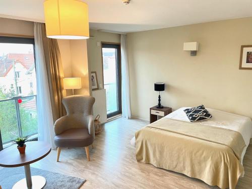 une chambre avec un lit, une chaise et une table dans l'établissement Résidence de Maisons-Laffitte, à Maisons-Laffitte