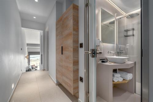 a bathroom with a sink and a mirror at Harmony Apartments in Agioi Apostoli