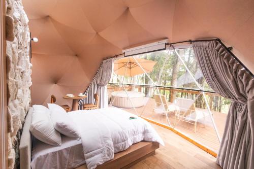 a bedroom with a bed and a balcony at Refúgio Bela Cabanas in Imaruí