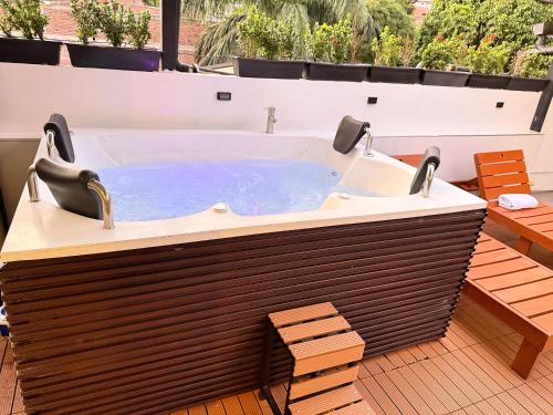 a jacuzzi tub on a patio with benches at HOTEL 9.5 SAN FERNANDO in Cali