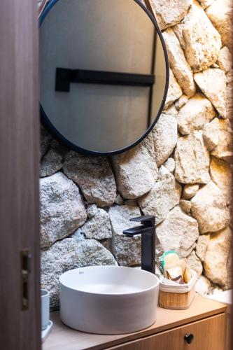 a bathroom with a sink and a mirror on a stone wall at Refúgio Bela Cabanas in Imaruí