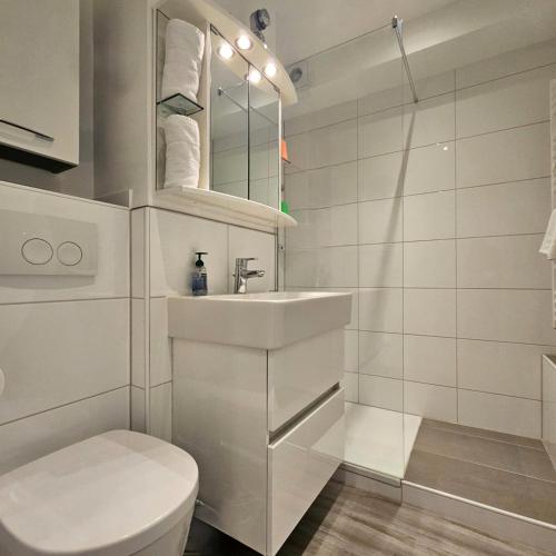 a white bathroom with a toilet and a sink at Ferienwohnung Panoramablick in Füssen