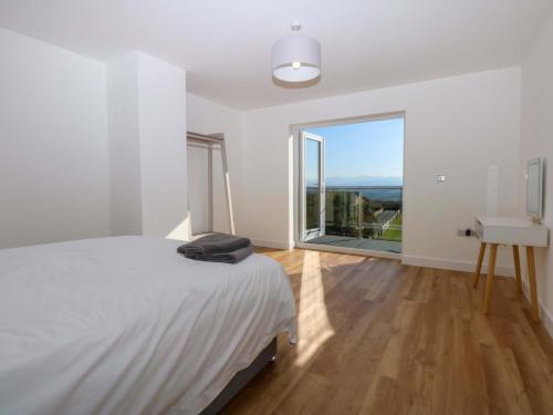 a bedroom with a bed and a desk and a window at Golygfa in Bodorgan