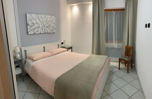 a small bedroom with a bed and a chair at FUORI PORTA NUOVA in Sarzana