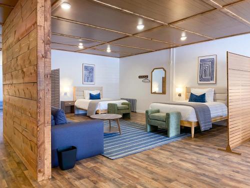 a hotel room with two beds and a couch at Wilder Bunkhouse in De Smet
