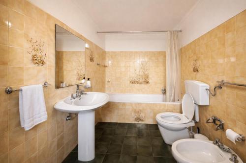 a bathroom with a sink and a toilet and a tub at Cascais Little Garden Rooms Old Town in Cascais