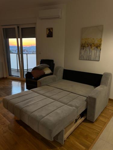 a large bed in a living room with a couch at SIENA stan na dan Doboj in Doboj