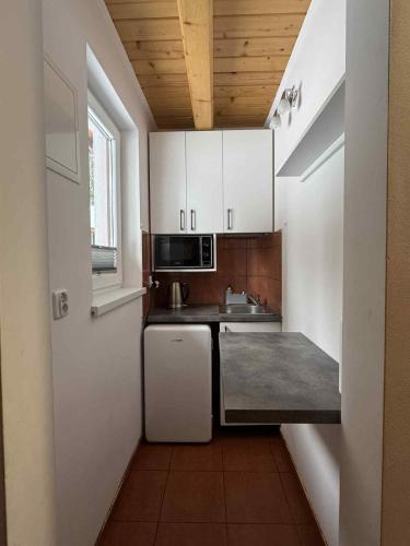 a small kitchen with white cabinets and a sink at Ośrodek Nad Potokiem in Poręba Wielka