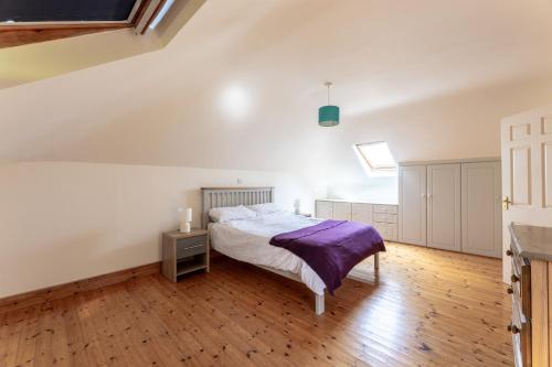 a bedroom with a bed and a wooden floor at Ballyneill Farmhouse in Carrick-on-Suir