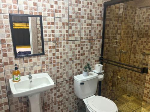 a bathroom with a toilet and a sink and a mirror at Casa Bandera 54 in Guayabal
