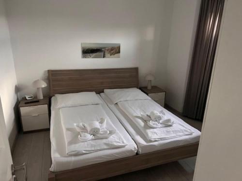 a bedroom with a bed with two towels on it at Nordsee 03 in Cuxhaven
