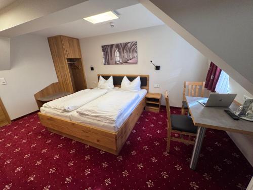 a bedroom with a bed and a desk and a laptop at Doppelzimmer 11 in Heidenheim