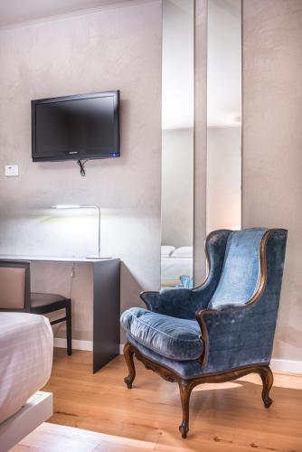 a living room with a chair and a tv at Point Hotel in Piove di Sacco