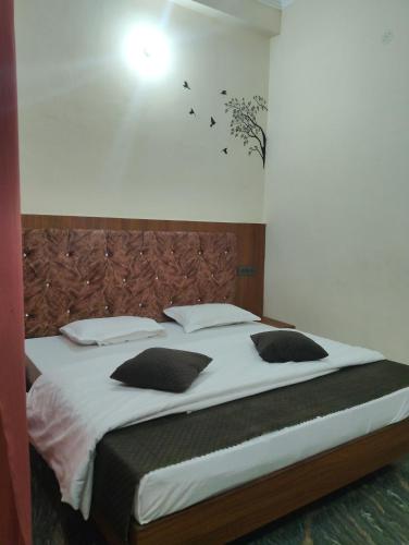 a bedroom with a large bed with birds on the wall at Nanda devi hotel in Mussoorie