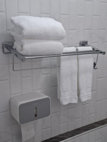 a bathroom with a shelf with towels and a toilet at Adira Residence in Ao Nang Beach