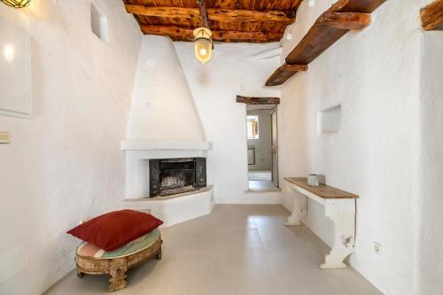 a white room with a fireplace and a table at Ca Na Ramona - Finca with Pool Santa Eularia in Santa Eularia des Riu