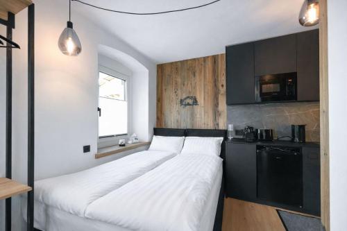two beds in a small room with a kitchen at Kitz Alpine Apartments - City Center in Kitzbühel