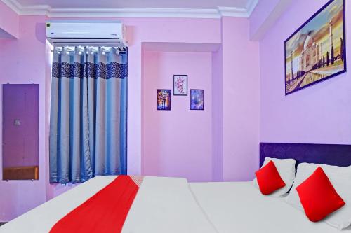 a bedroom with a large bed with red pillows at Super Hotel O New View in Bankipur