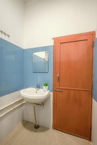 a bathroom with a sink and a wooden door at Bir Downtown in Bīr