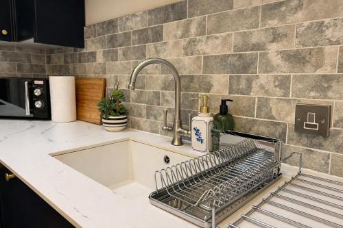 a kitchen sink with a dish drying rack on it at The Old Borough Library - Staffordshire in Stafford