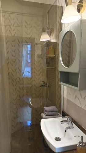 a bathroom with a sink and a shower and a mirror at Bright Cozy Apartment in Riga Quiet Center in Riga