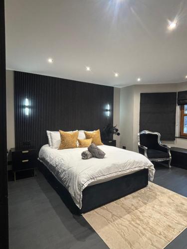 a bedroom with a large bed and a chair at Large Modern Family Home in Murrayfield - Very close to City Centre - 10 mins by Direct Bus - Private Driveway & Garden in Edinburgh