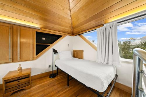 a small bedroom with a bed and a window at Brighton Carriage House in Rosemary Beach
