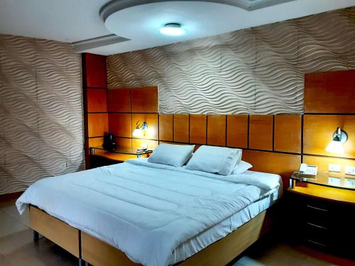 a bedroom with a large bed with two lamps at Hotel Presidente Asunción in Asunción