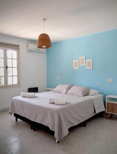 a bedroom with a large bed with a blue wall at Roque 4047 in San Juan