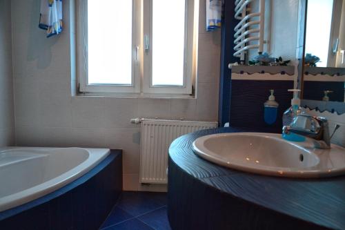 a bathroom with a sink and a tub and a mirror at Hotel Restauracja Małopolska in Jasło