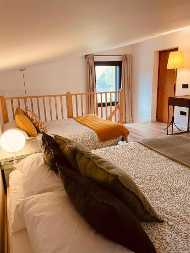 a bedroom with two beds and a window at Alojamiento Rural Montseny in Breda