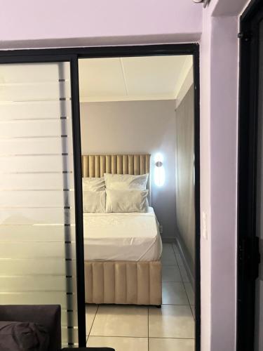 a bedroom with a bed and a mirror at Lagoon escape Apartment in Pretoria