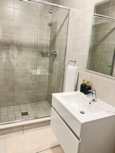 a bathroom with a sink and a shower at Lagoon escape Apartment in Pretoria