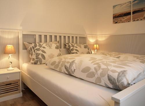 ハイリゲンハーフェンにあるStrandhaus Heiligenhafenのベッドルーム(大きな白いベッド、枕付)
