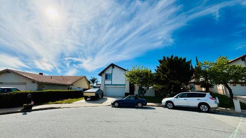 two cars parked in a parking lot in front of a house at Joshiehome in Rancho Cucamonga