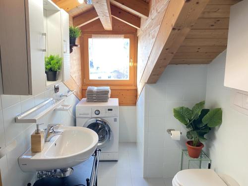 a bathroom with a sink and a washing machine at My Sweet Home In The Dolomites - Casa LaLu in Cavalese