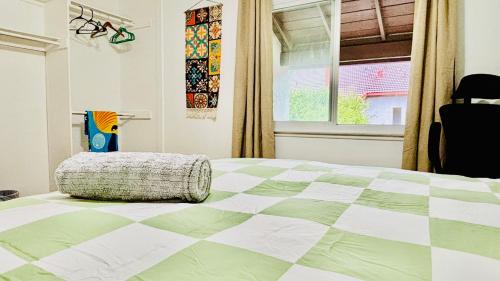 a bedroom with a green and white bed with a window at Joshiehome in Rancho Cucamonga