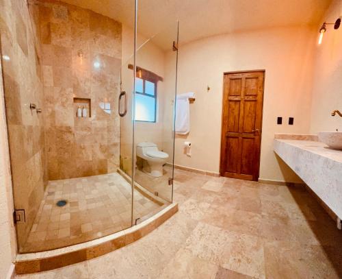 a bathroom with a glass shower and a toilet at Hotel Suites Piamonte in Bernal