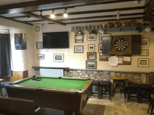 um quarto com uma mesa de bilhar e uma televisão em The Foresters Arms em Grassington