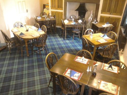 uma sala de jantar com mesas e cadeiras de madeira em The Foresters Arms em Grassington