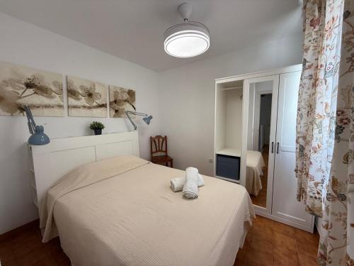 a bedroom with a bed with a towel on it at Casa de playa los Alamos Andra in Torremolinos