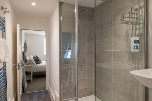 a bathroom with a shower with a glass door at Tides Door in Dartmouth