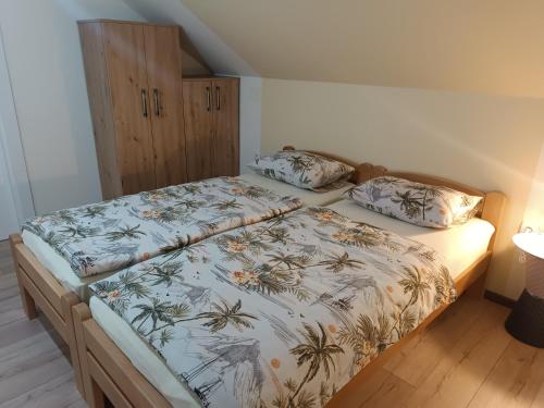 a bedroom with a bed with a bedspread with plants on it at Imanje Mihailovic 3 in Pružatovac