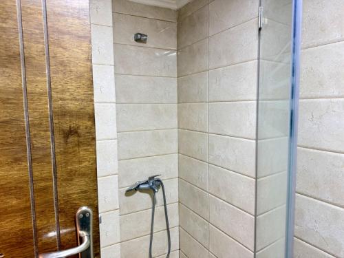 a shower with a hose in a bathroom at Les Voiles Kfar Aabida in Fad‘ūs