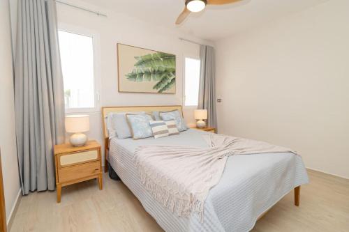 a bedroom with a bed and two lamps and a window at 3 Bedroom Villa in Estrella in Dominica