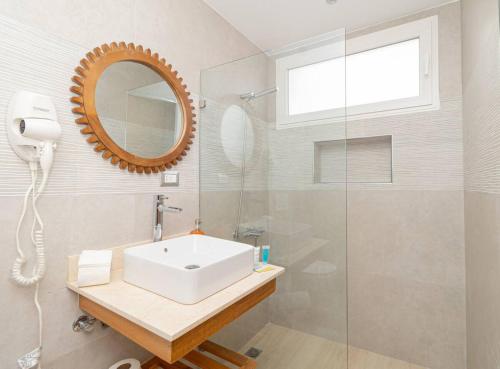 a bathroom with a sink and a mirror and a shower at 3 Bedroom Villa in Estrella in Dominica